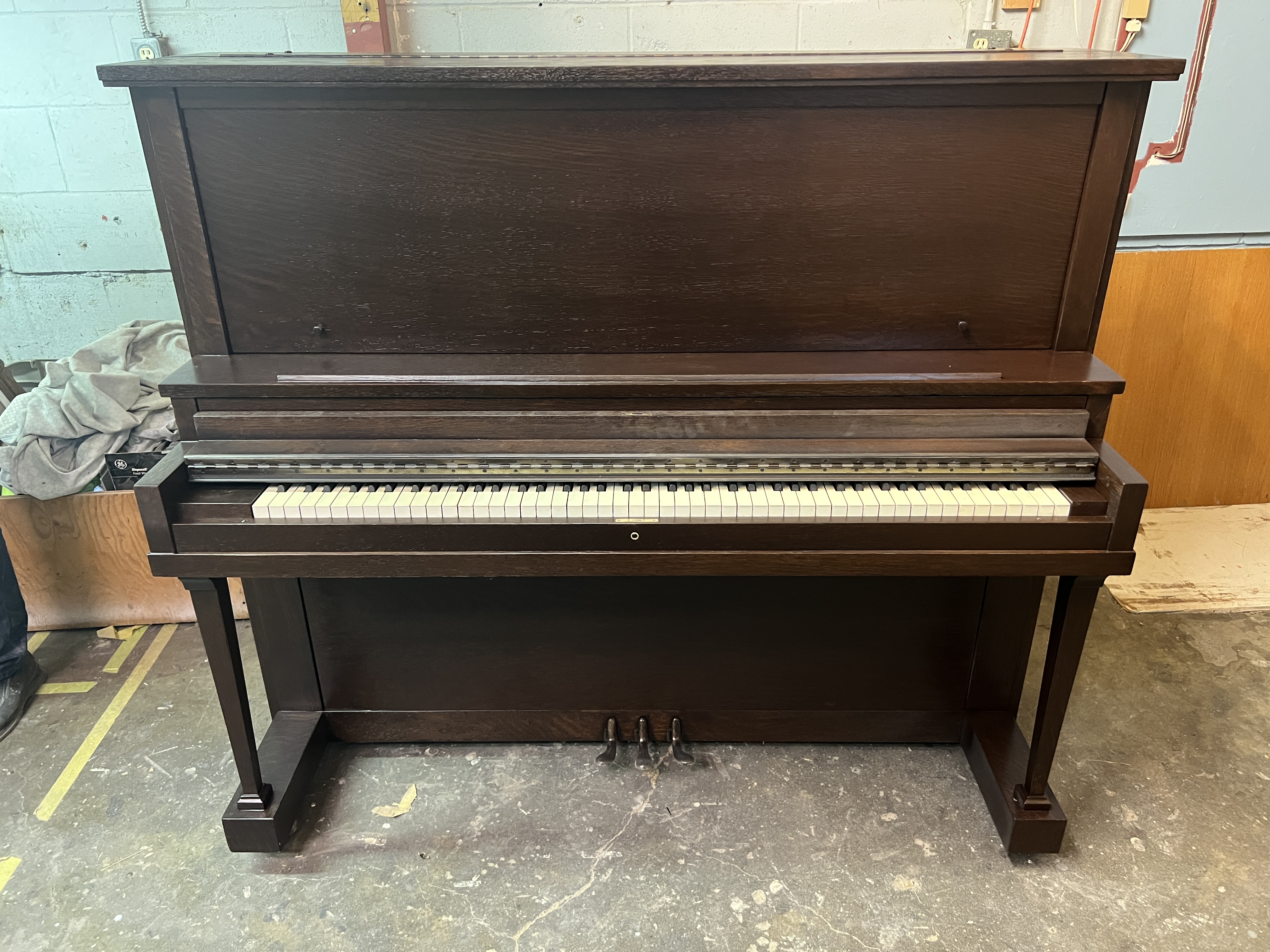 An upright piano refinished in a dark brown color