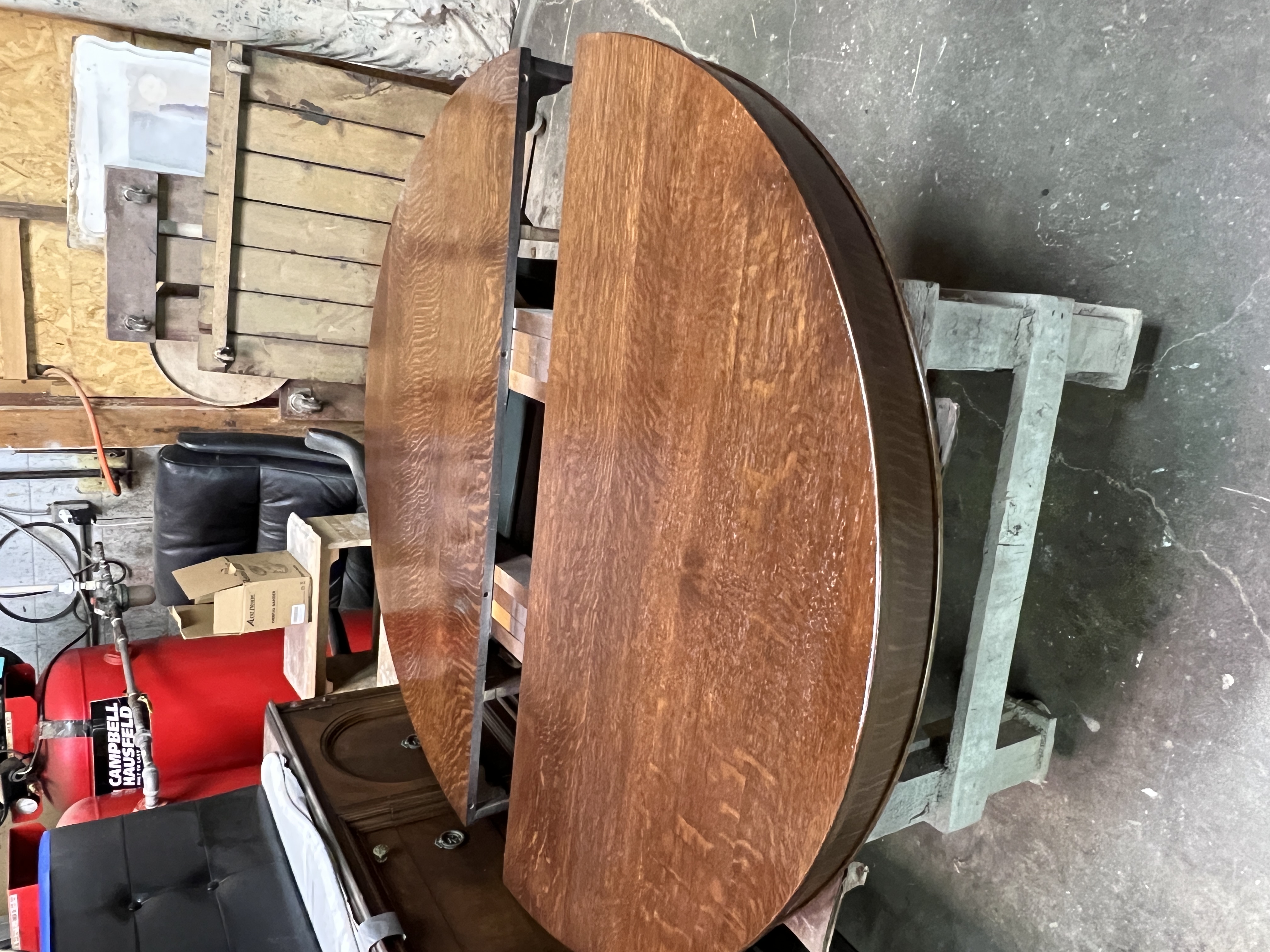 A brown wooden extendable table with two circular halves