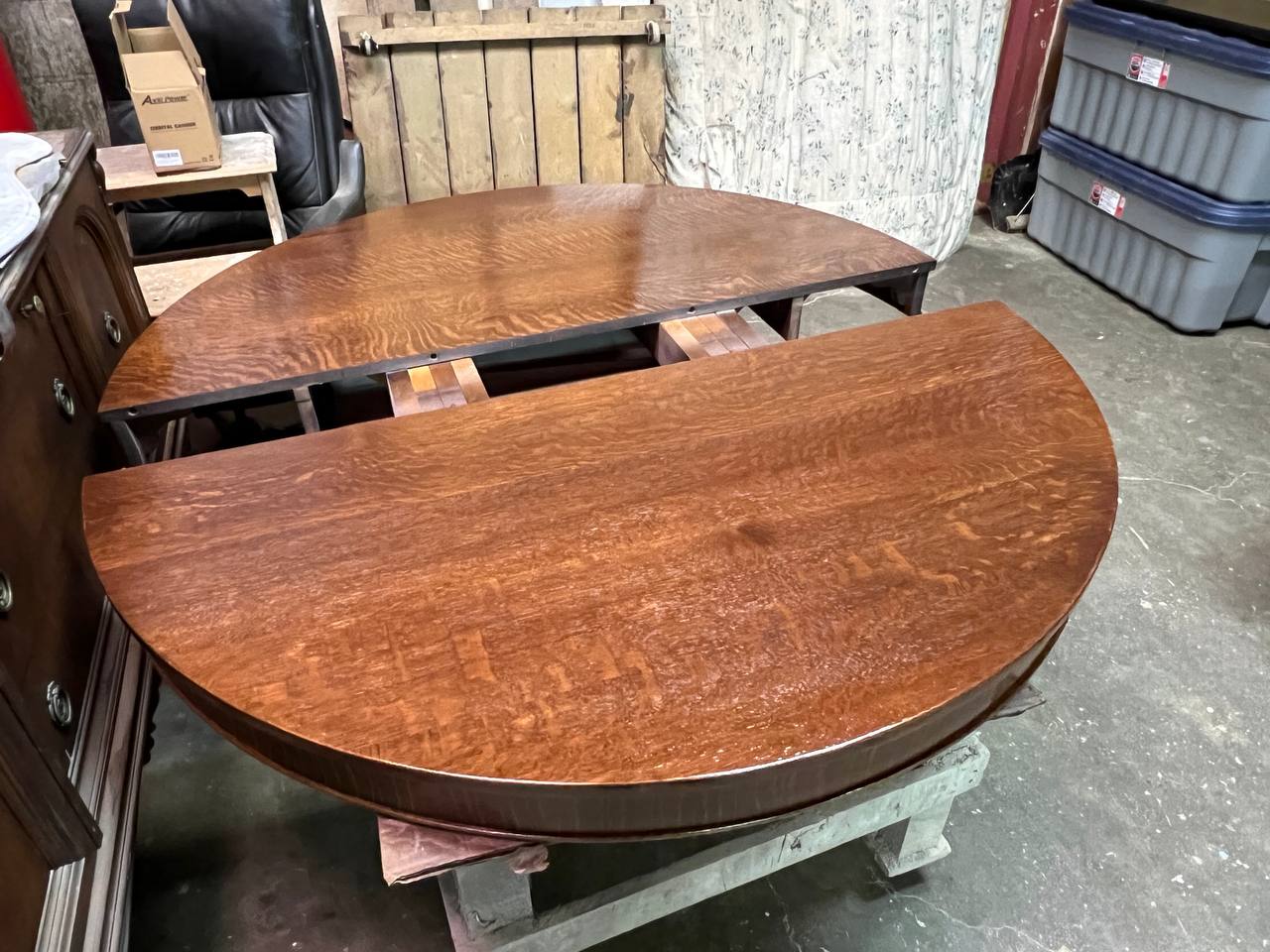 A brown wooden extendable table with two circular halves