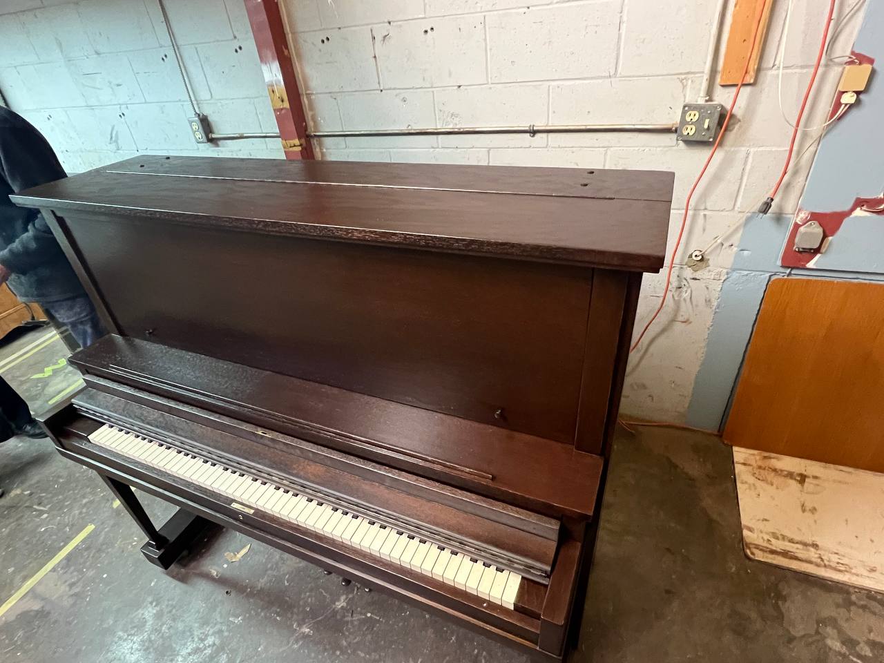 An upright piano refinished in a dark brown color