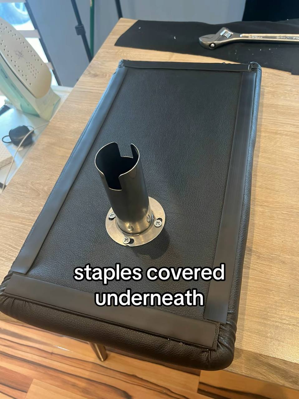 Underside of a black upholstered center console armrest