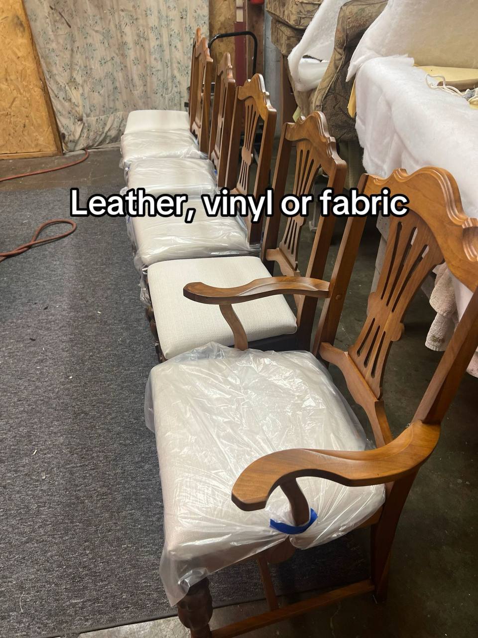 4 wooden dining chairs and armchair with a medium to dark-toned hardwood frame, featuring turned legs and a vertical slat backrest with a curved top rail, upholstered in white-colored fabric