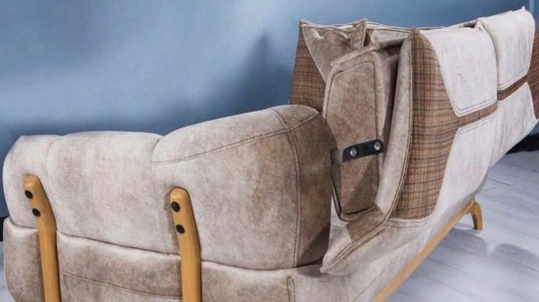 Convertible beige sleeper sofa with brown plaid accents