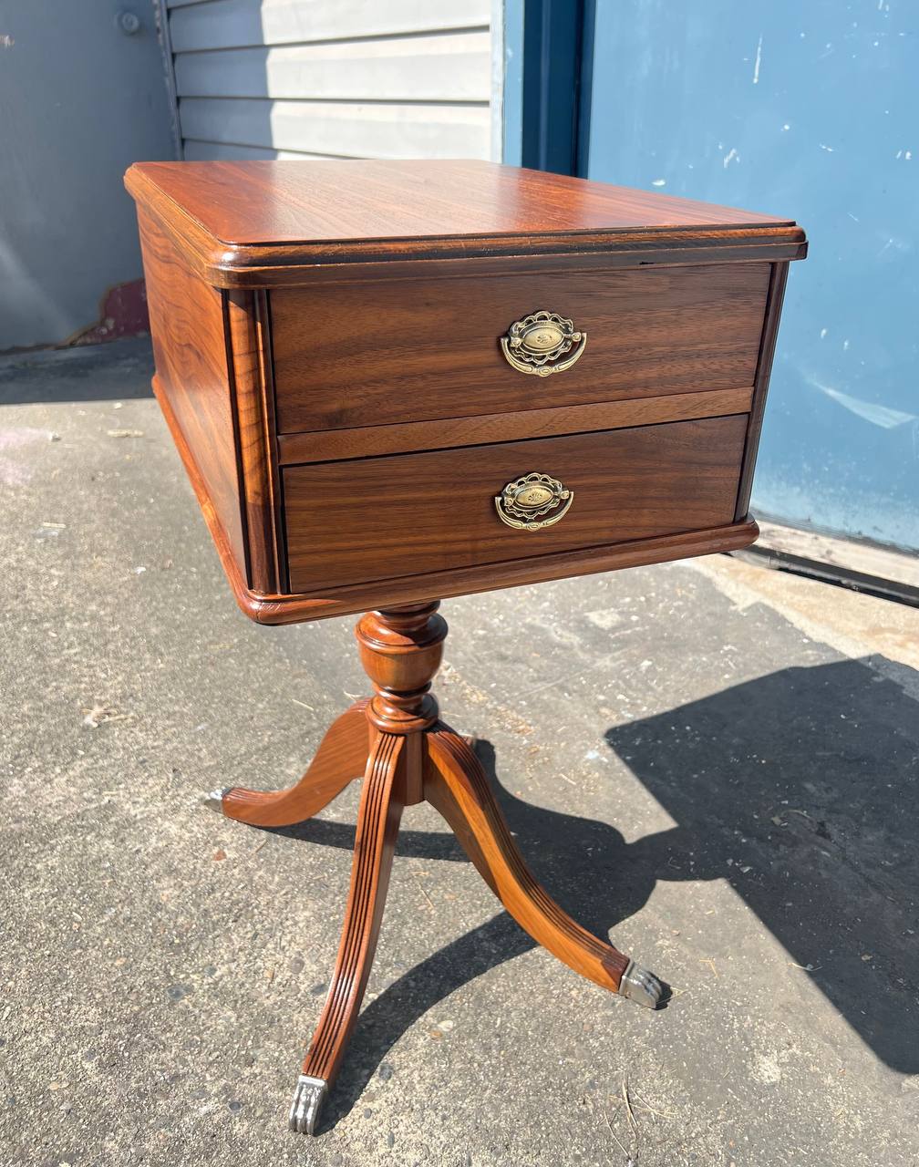 Refinished wooden side table with a rich walnut finish, two brass-accented drawers, and curved pedestal legs featuring metal foot caps