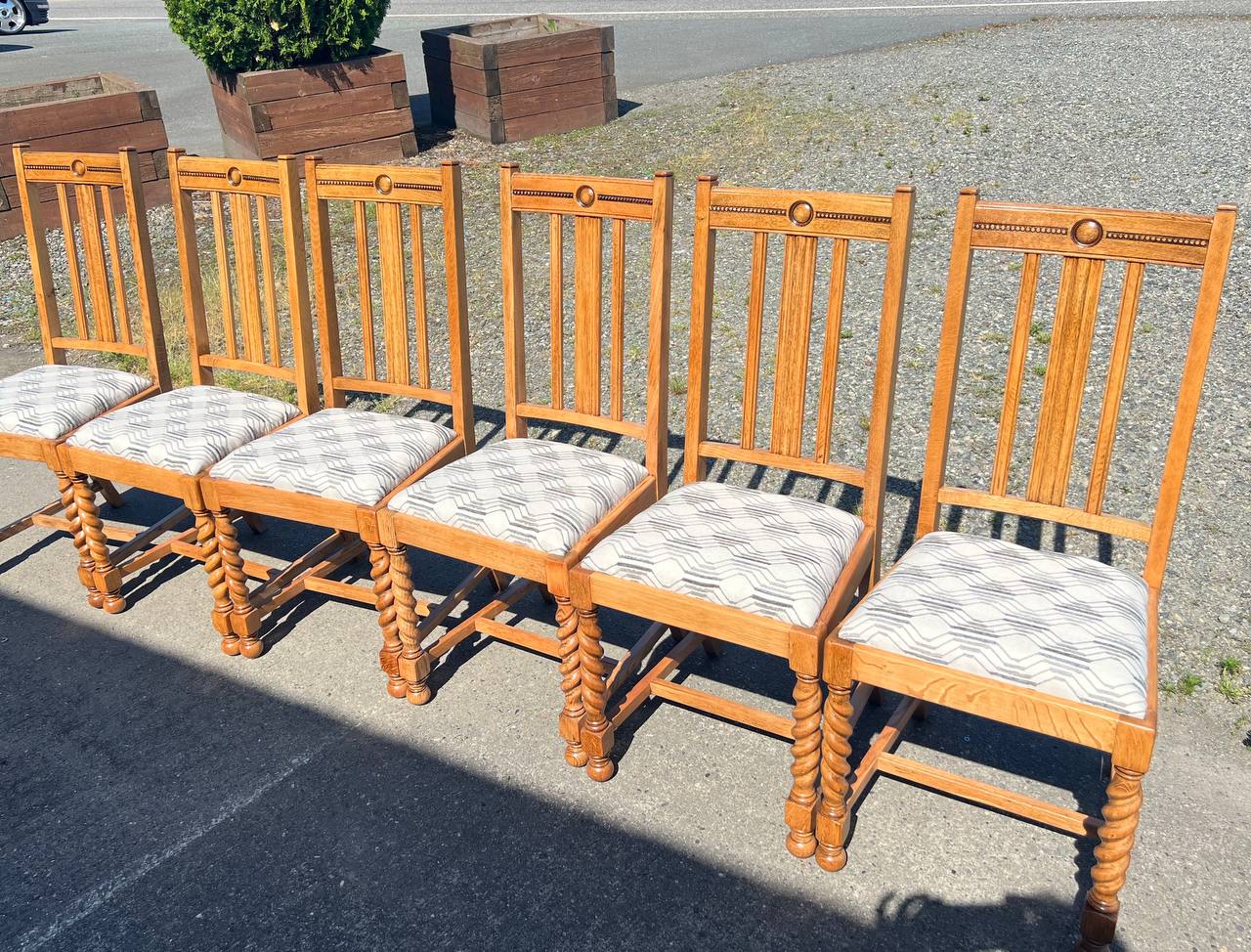 6 dining chairs featuring light wood frames and reupholstered patterned fabric seats