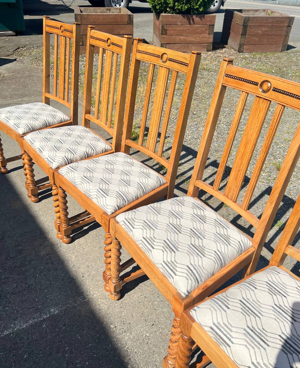 6 dining chairs featuring light wood frames and reupholstered patterned fabric seats