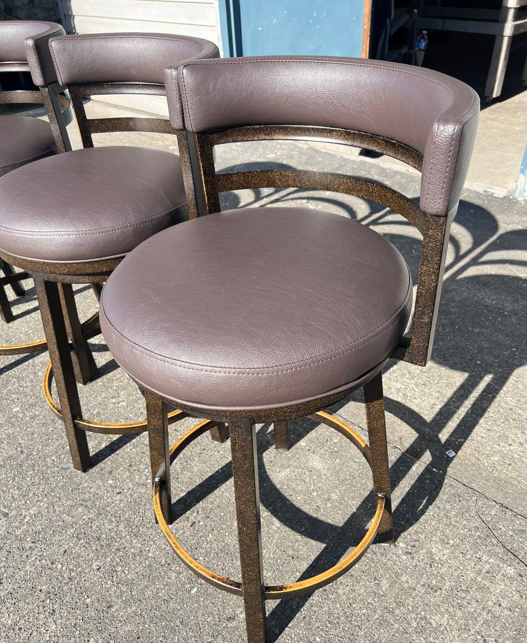 Brown leather-like upholstered bar stool with a curved backrest and metal legs in a contemporary design
