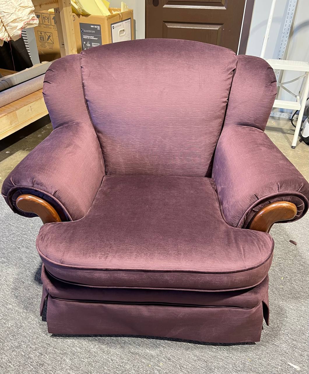 Plush rolled-arm armchair upholstered in solid plum fabric with wooden trim accents.