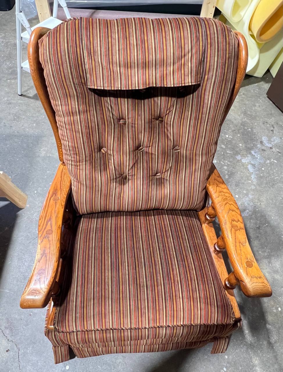 Vintage upholstered wooden armchair with vertical striped fabric in earthy tones and tufted backrest