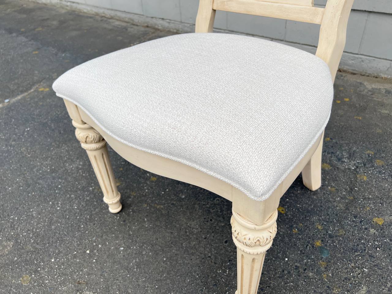 French Provincial-inspired dining chair with a cream ornate carved backrest and white upholstered seat