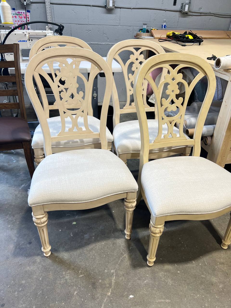 4  French Provincial-inspired dining chairs with a cream ornate carved backrest and white upholstered seat