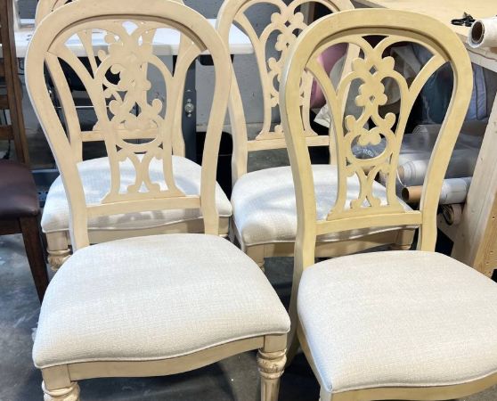 4 French Provincial-inspired dining chairs with a cream ornate carved backrest and white upholstered seat