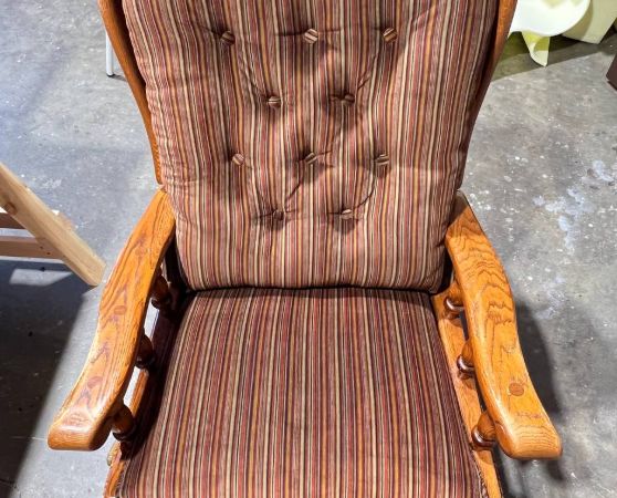 Vintage upholstered wooden armchair with vertical striped fabric in earthy tones and tufted backrest