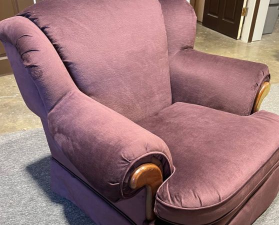 Plush rolled-arm armchair upholstered in solid plum fabric with wooden trim accents.