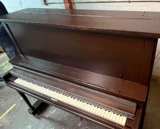 An upright piano refinished in a dark brown color