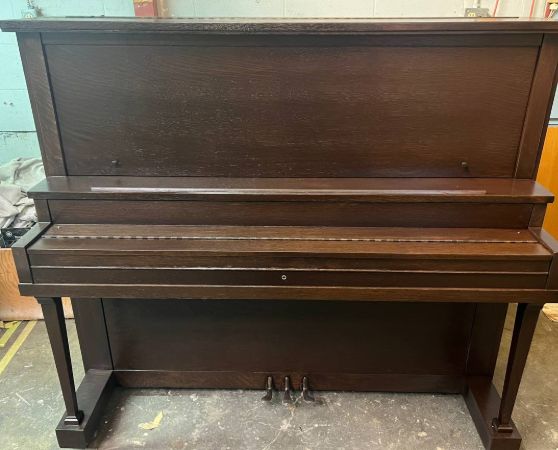 An upright piano refinished in a dark brown color