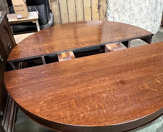 A brown wooden extendable table with two circular halves