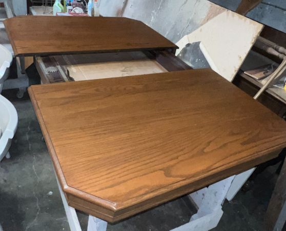 Medium oak extendable dining table with woodgrain finish and central leaf opening