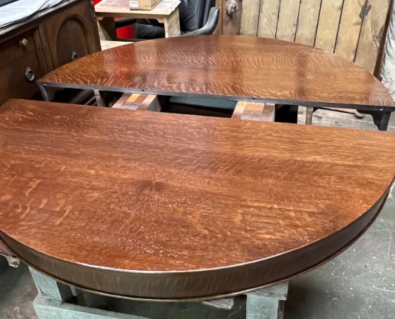 A brown wooden extendable table with two circular halves