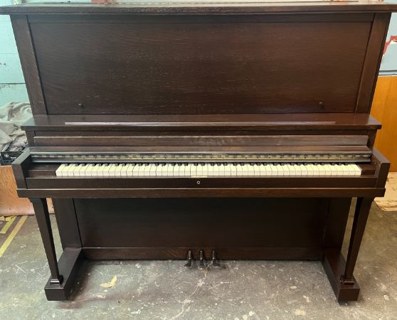 An upright piano refinished in a dark brown color
