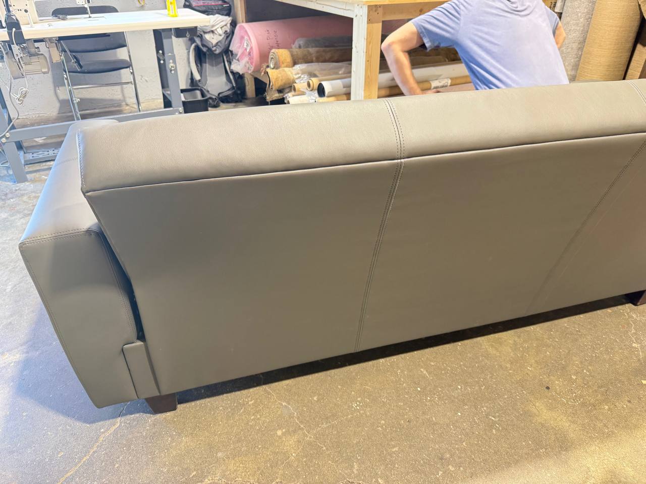 Back of the sleek modern gray vinyl sofa with straight lines and wide arms