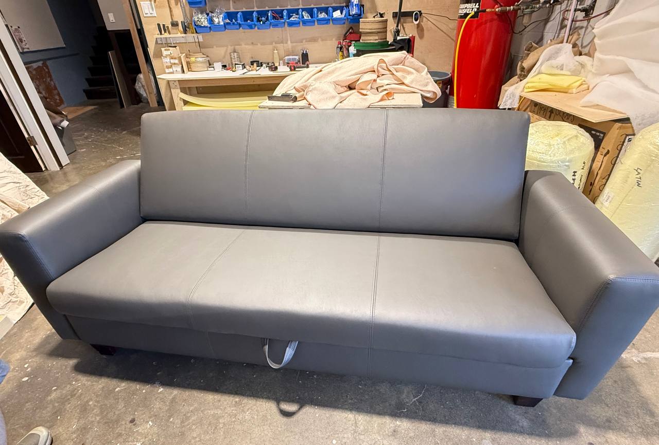 Sleek modern gray leatherette sofa with straight lines and wide arms
