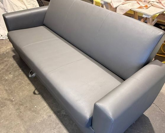 Sleek modern gray leatherette sofa with straight lines and wide arms