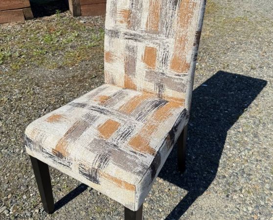 High-back dining chair with abstract beige, brown, and gray upholstery and dark wooden legs.