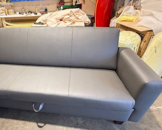 Sleek modern gray leatherette sofa with straight lines and wide arms