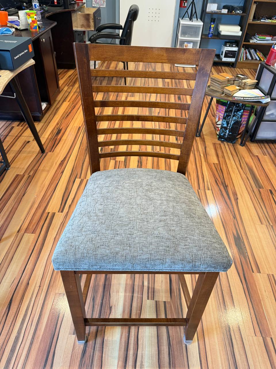 Brown wooden chair with gray cushioned seat, modern slatted design