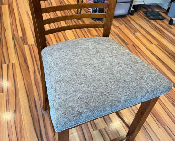 Brown wooden chair with gray cushioned seat, modern slatted design.