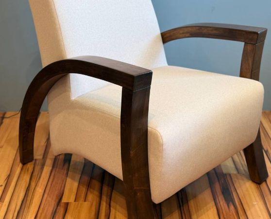 Beige modern armchair with dark wood arms and legs.