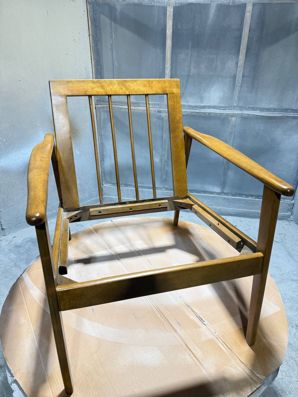 Refinished wooden frame of a mid-century armchair.
