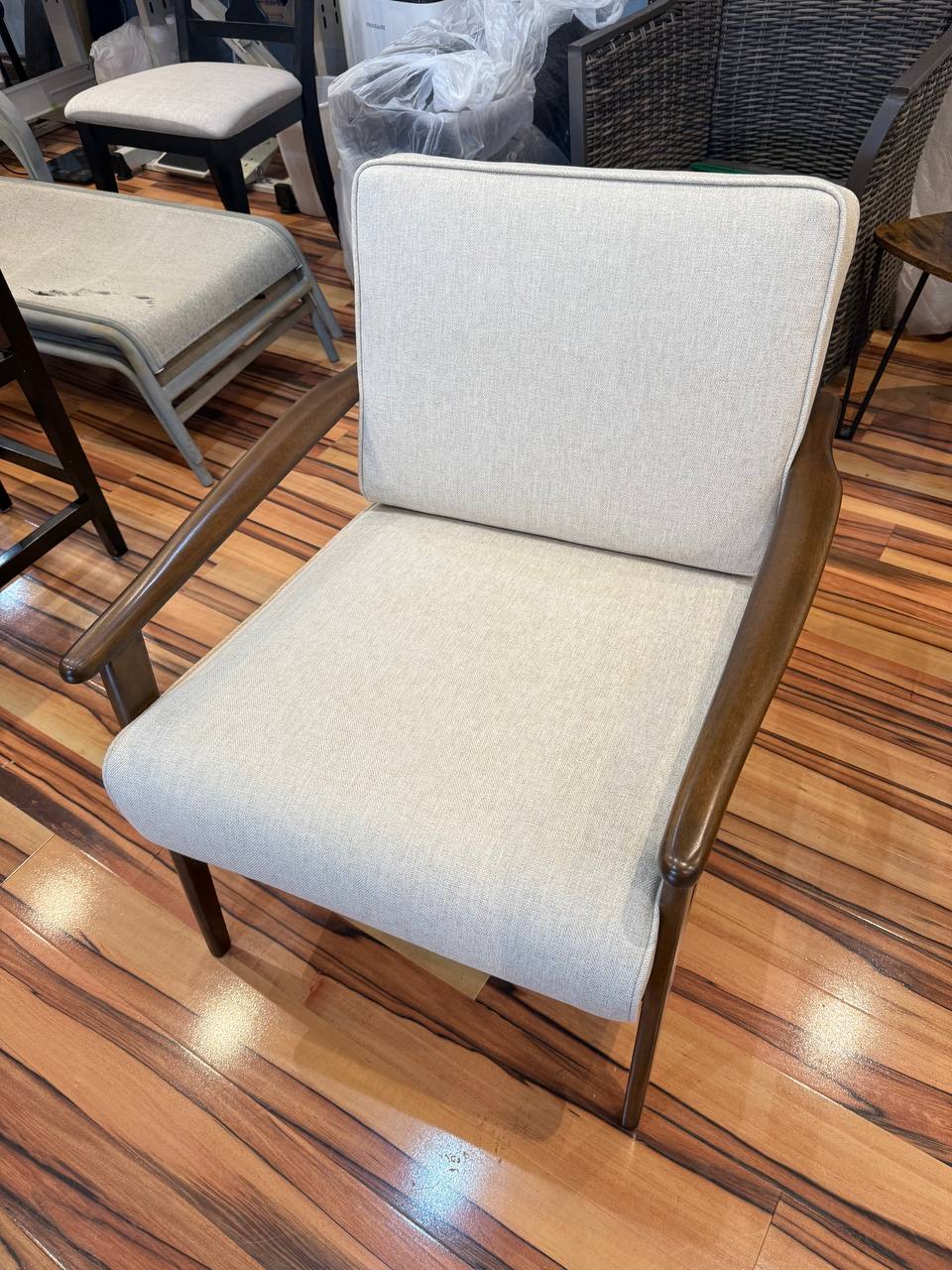 Beige fabric armchair with walnut arms, mid-century style.