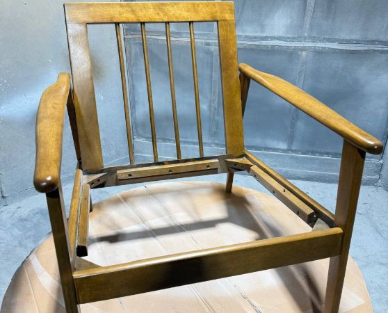 Refinished wooden frame of a mid-century armchair.