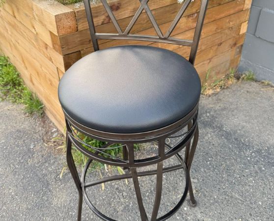 Black metal barstool with gray cushioned seat and wooden backrest