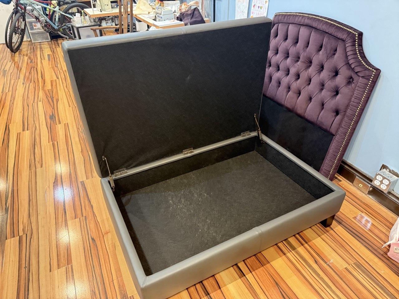 Modern gray storage ottoman, upholstered in sleek fabric with a lift-top design for storage.