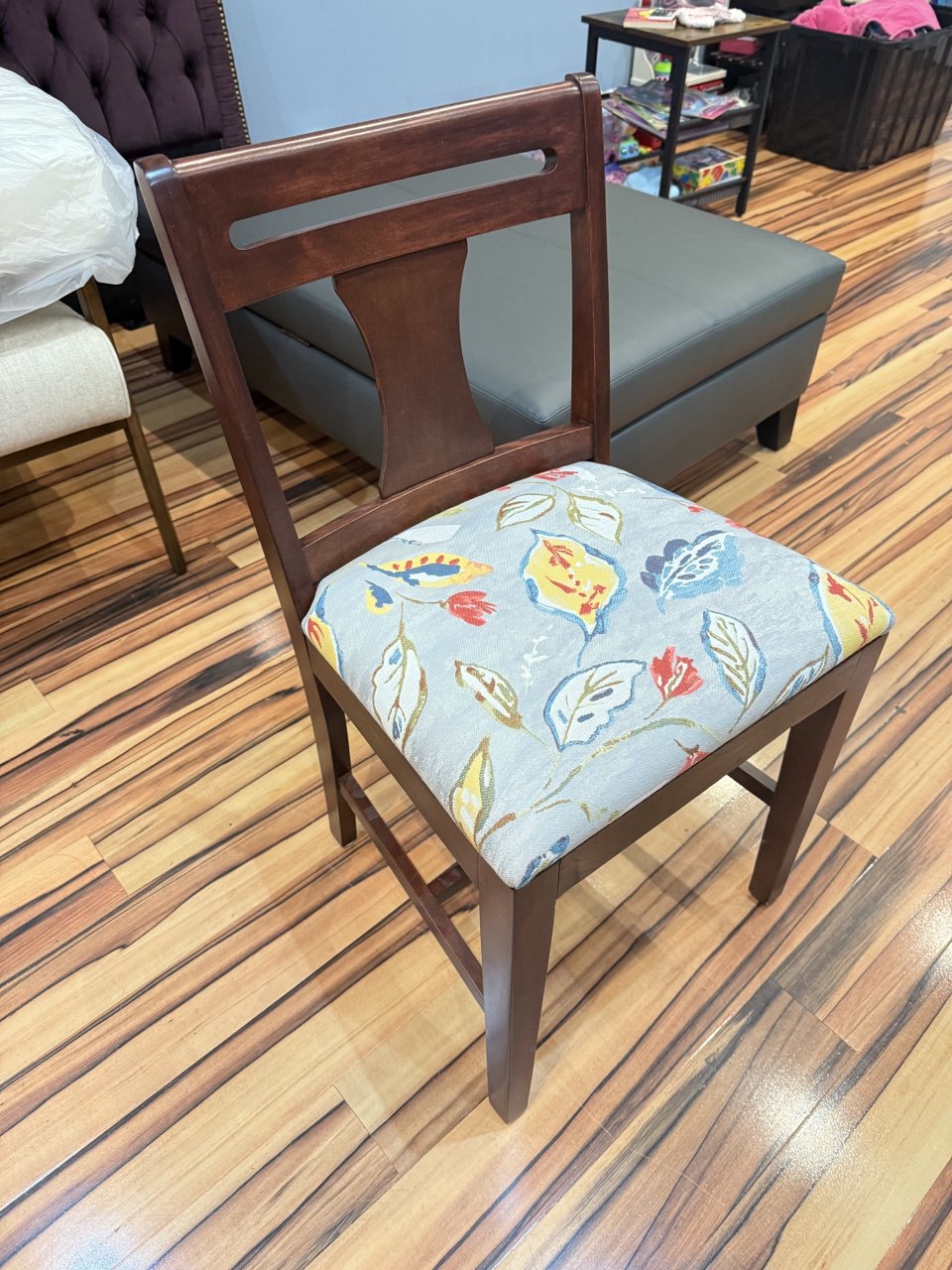Modern dark wood dining chair with a vibrant floral fabric