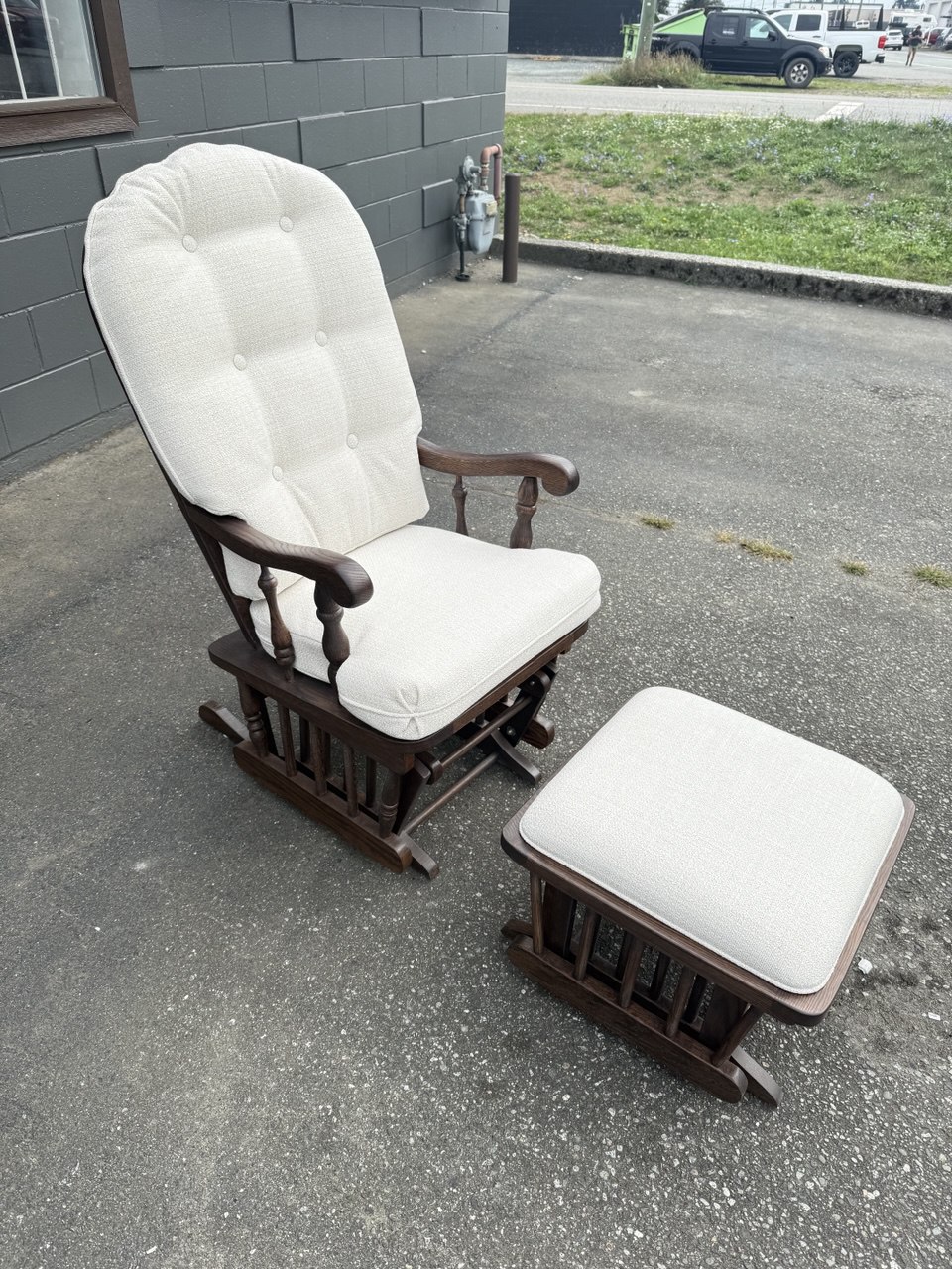 Refinished and reupholstered classic glider rocking chair and ottoman set, featuring cream fabric with tufted detailing.