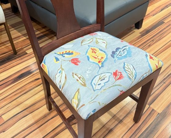 Modern dark wood dining chair with a vibrant floral fabric