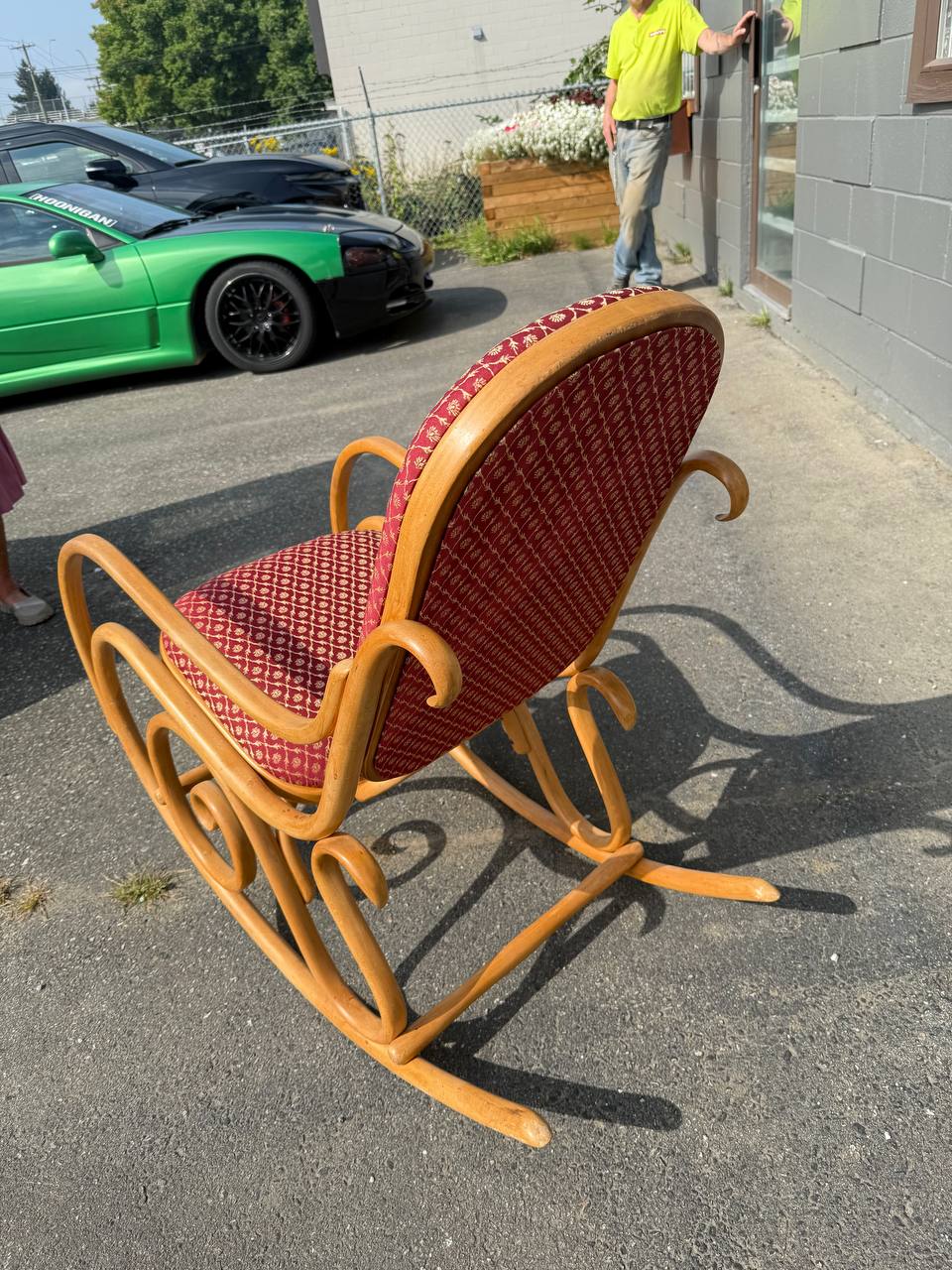 Back of the elegant bentwood rocking chair with a red patterned upholstered seat and back
