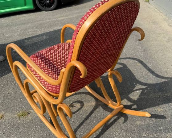 Back of the elegant bentwood rocking chair with a red patterned upholstered seat and back