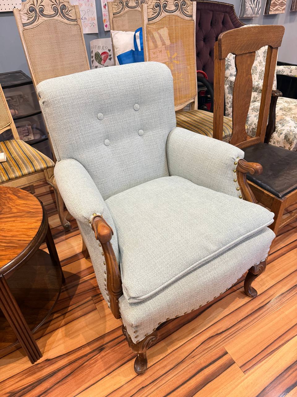 reupholstered antique armchair in light blue fabric with tufted button