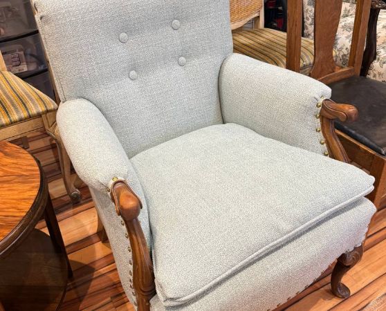 reupholstered antique armchair in light blue fabric with tufted button