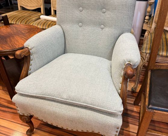 reupholstered antique armchair in light blue fabric with tufted button