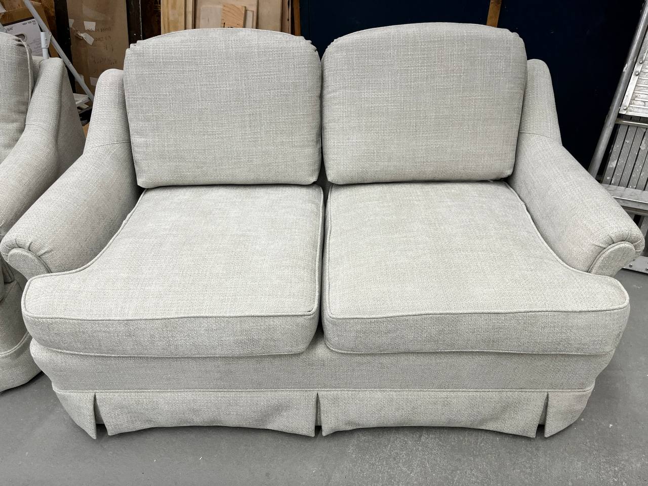 Reupholstered Loveseat with skirted base and rolled arms in light gray fabric