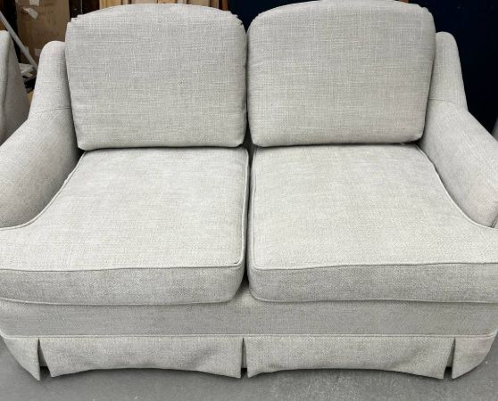 Reupholstered Loveseat with skirted base and rolled arms in light gray fabric