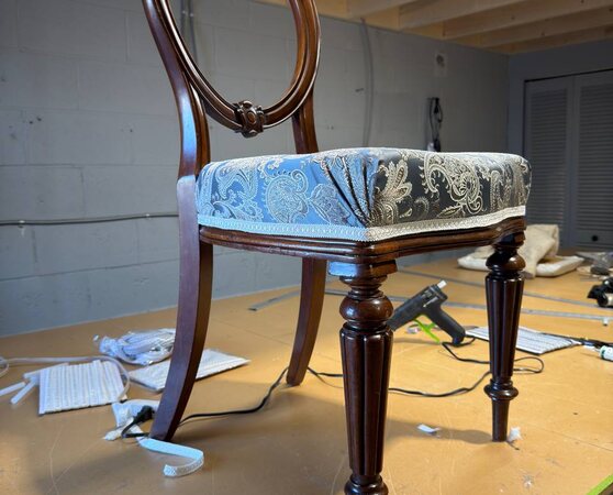 Ornate dark wood chair with a blue grey and beige paisley upholstered seat