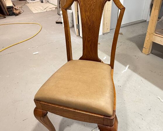 Traditional wood dining chair with a tan upholstered seat