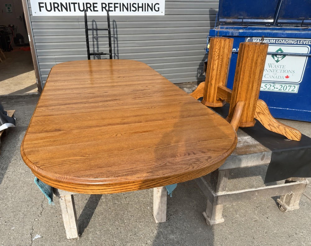 Refinished oak dining tabletop and extension leaves showing a warm golden finish, rounded edge and natural grain.